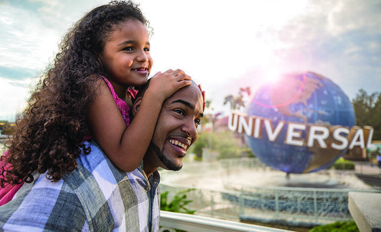 A father with his daughter at Universal Orlando Resort, with the Universal globe in the background