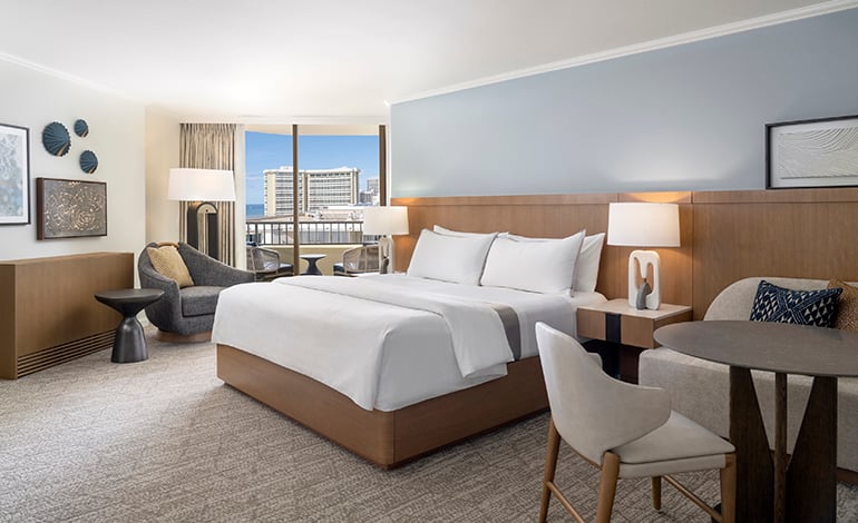 Corner view hotel room with a tall building visible through the window