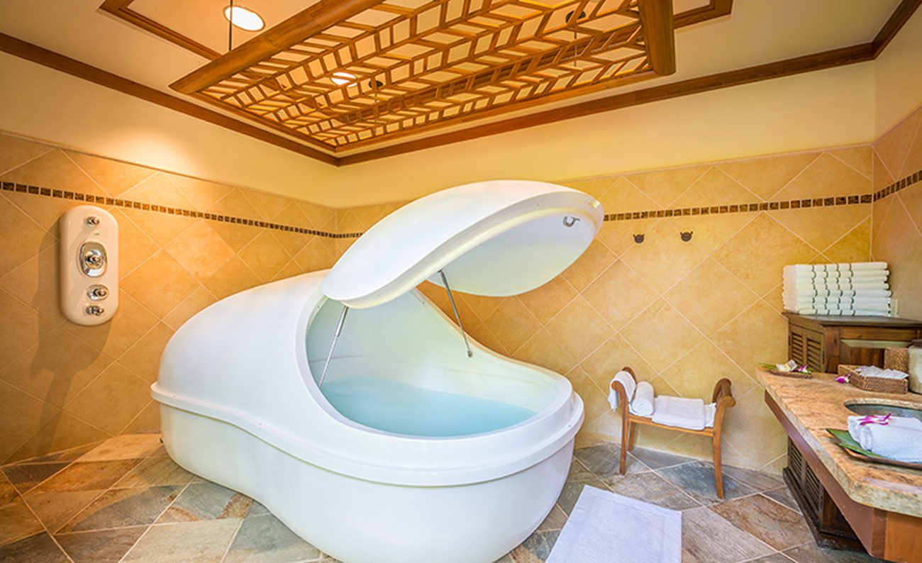A white pod filled with water in a tiled room