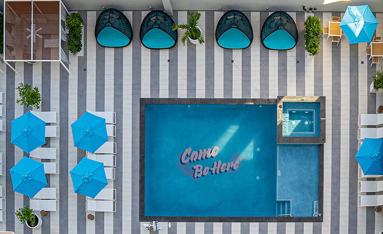 Overhead view of a pool that says in the tile, Come Be Here