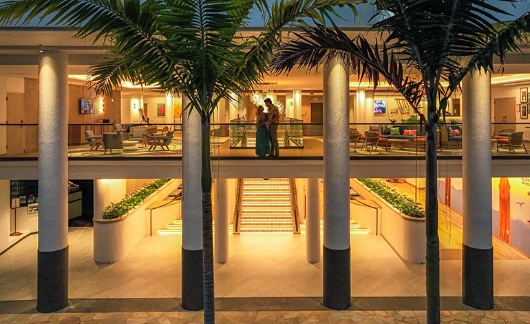 Evening photo of a couple on the second story terrace of a hotel lobby