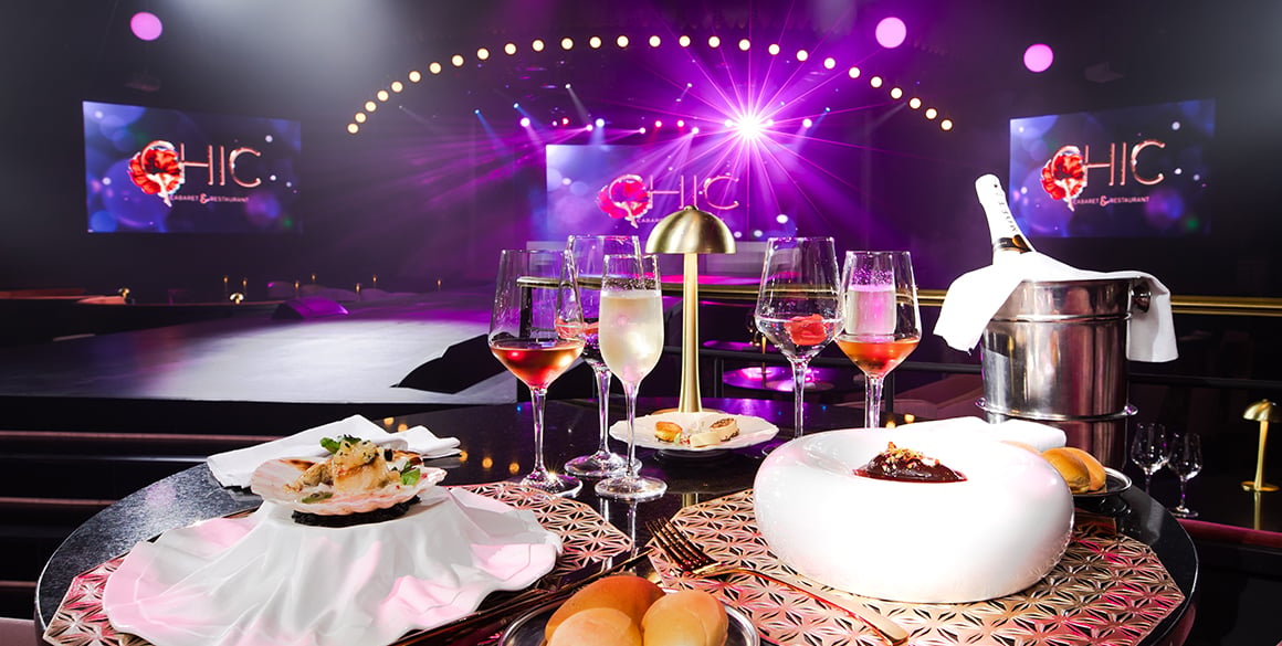 Contemporary dishes and wineglasses on a table facing a stage