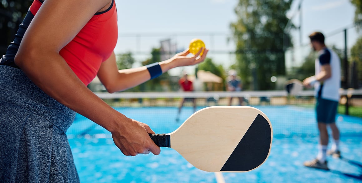 Woman getting ready to serve on a pickleball court