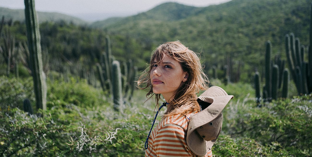 Woman in a cactus field looking backward