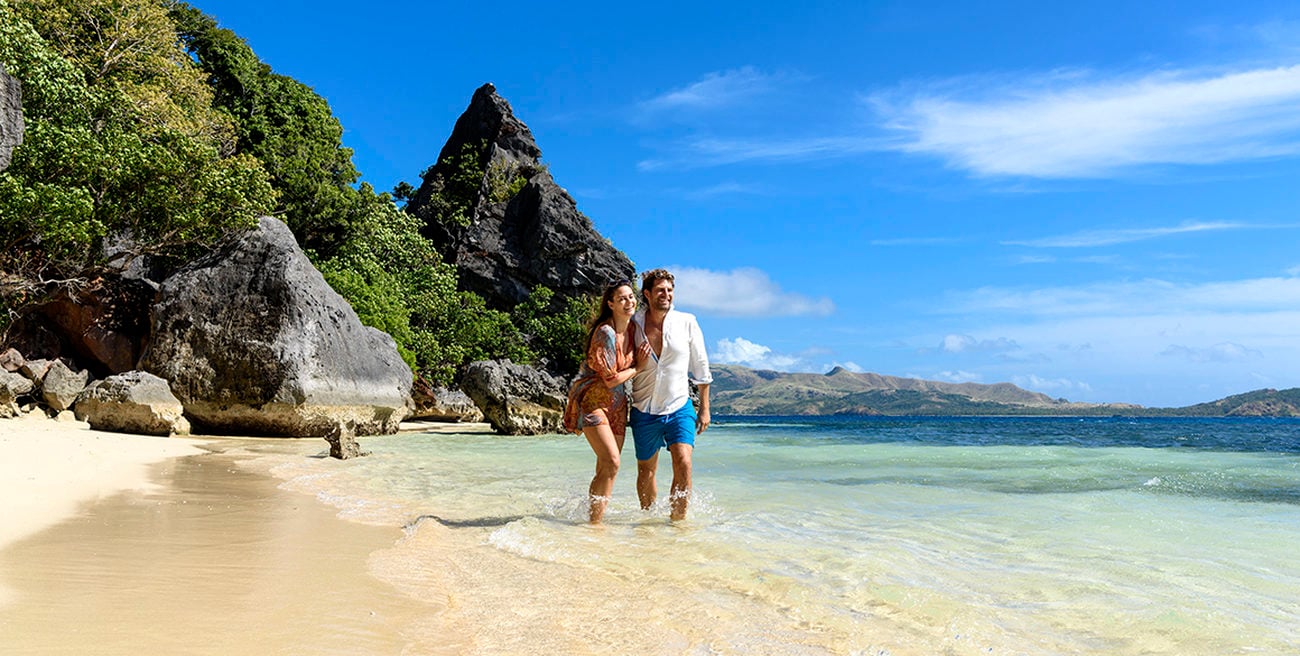 Hetero couple walking on a beach in Fiji