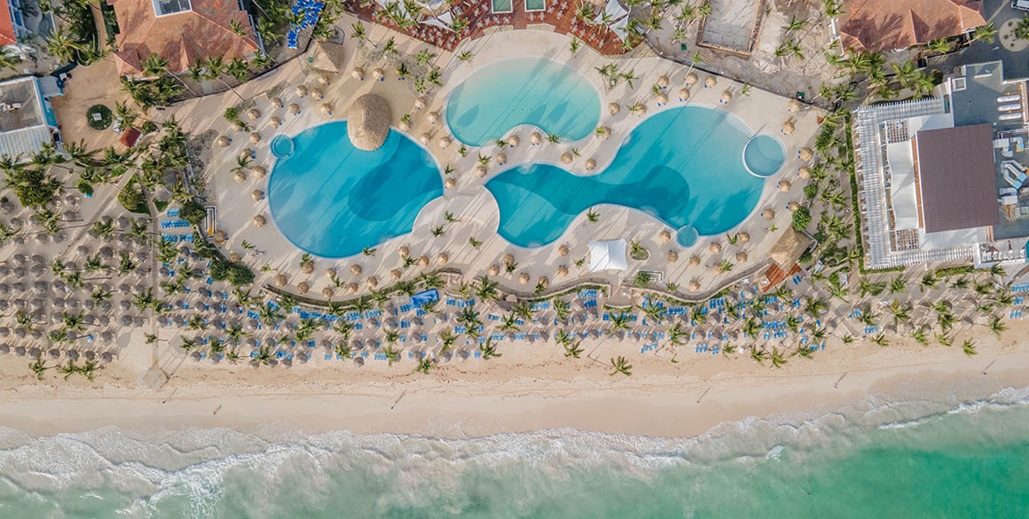 Overhead aerial view of three huge pools in the center of a resort complex