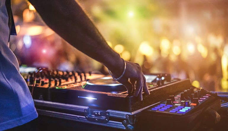 Abstract image of a DJ spinning to an evening crowd in Ibiza