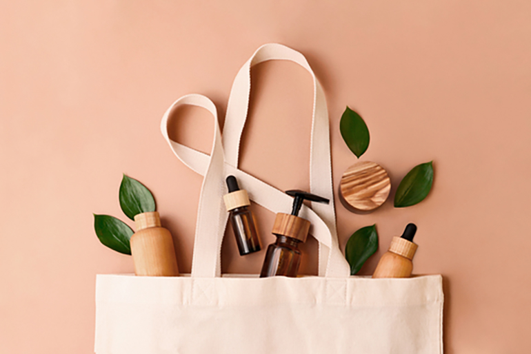 A tote bag with small bottles and leaves falling out.