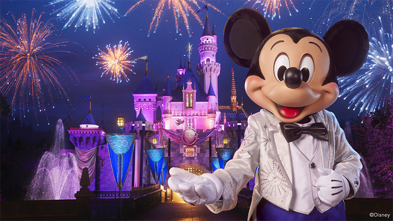 Mickey Mouse in front of Sleeping Beauty Castle at Disneyland with fireworks in the background