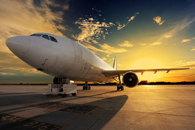 An airplane on the runway at sunset