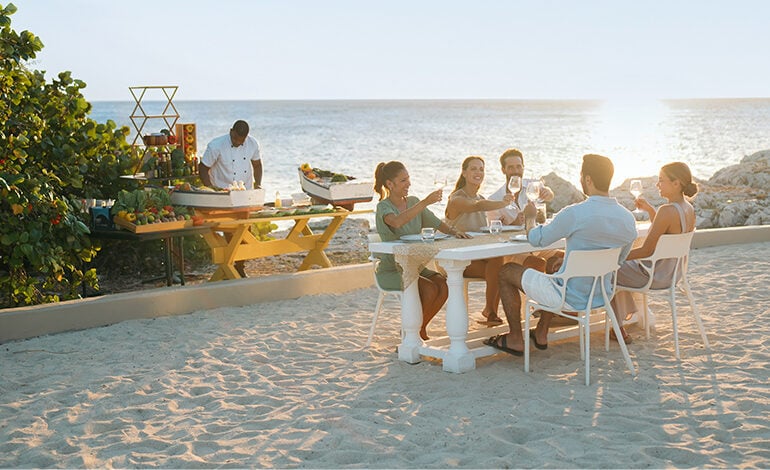 Group of four adults at a picnic table on the beach
