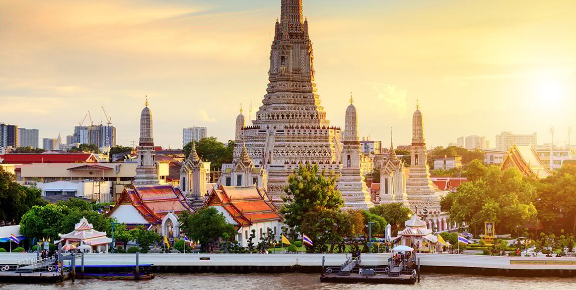 A sunset view of the riverfront Wat Arun temple in Bangkok, Thailand's Yai district.