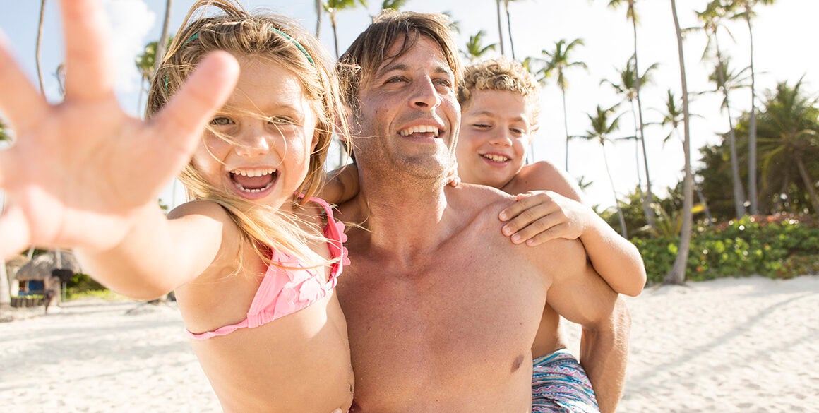 Man holding a girl and boy child