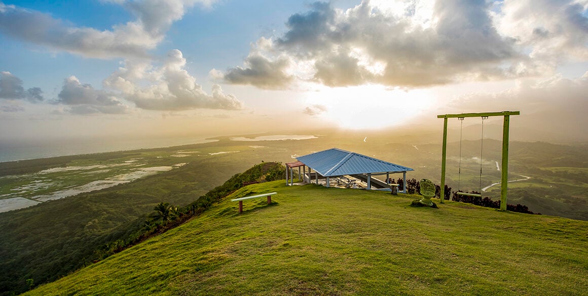 Sunrise over elevation of green hills