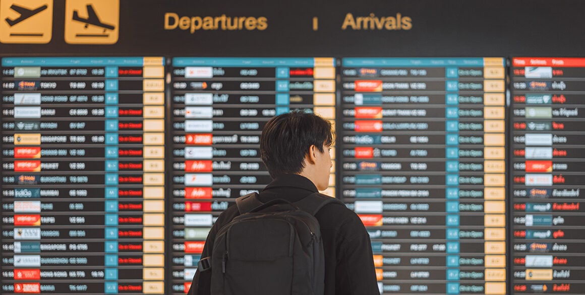 Man looking at flight board full of delays