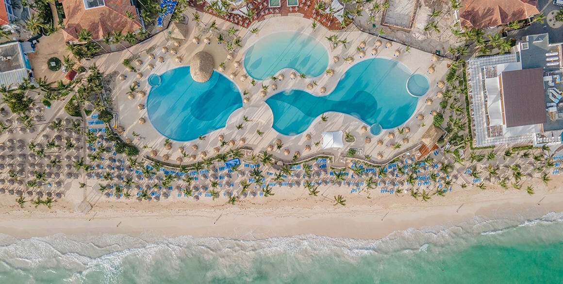 Overhead aerial view of three huge pools in the center of a resort complex