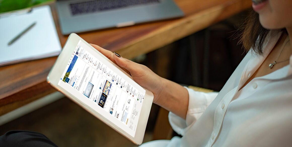 Woman's hands holding an iPad with a LinkedIn screen