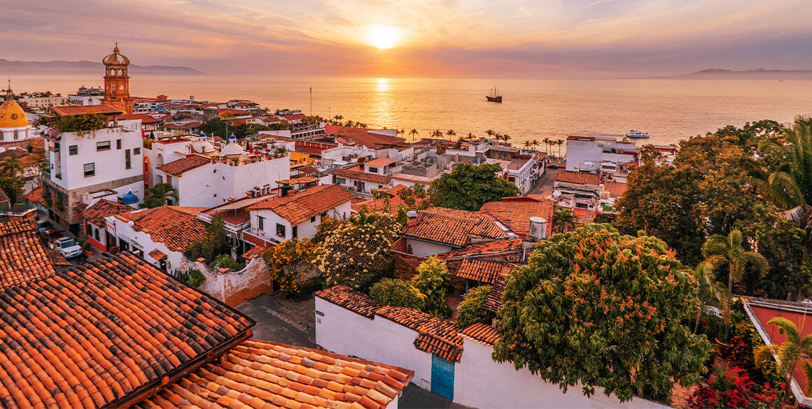 Sunrise over the water in a distance shot of Puerto Vallarta's downtown
