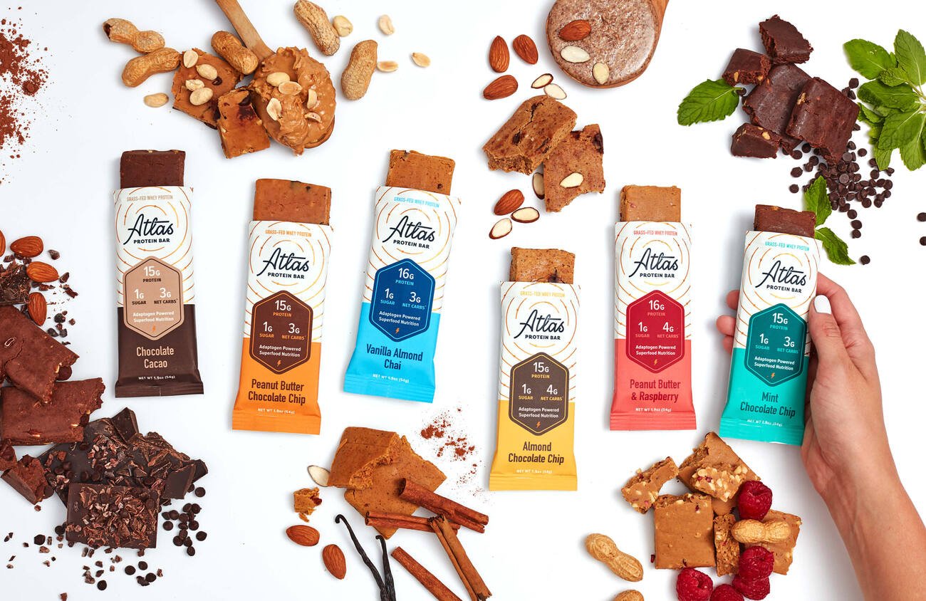Atlas Adaptogen Bars in packaging and out with ingredients laid out next to them