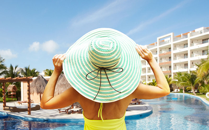 Woman wearing a floppy hat and looking at the pool