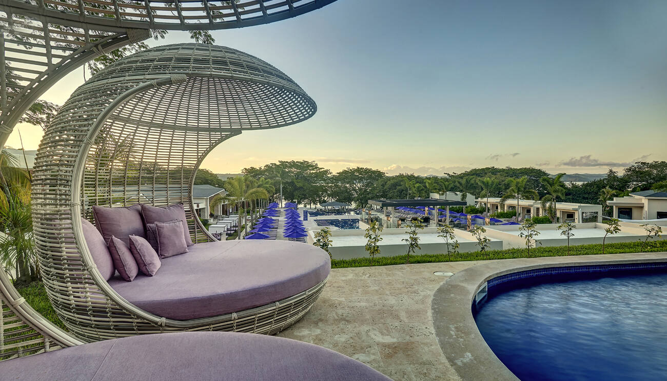 Canopy chairs by the pool overlooking the resort