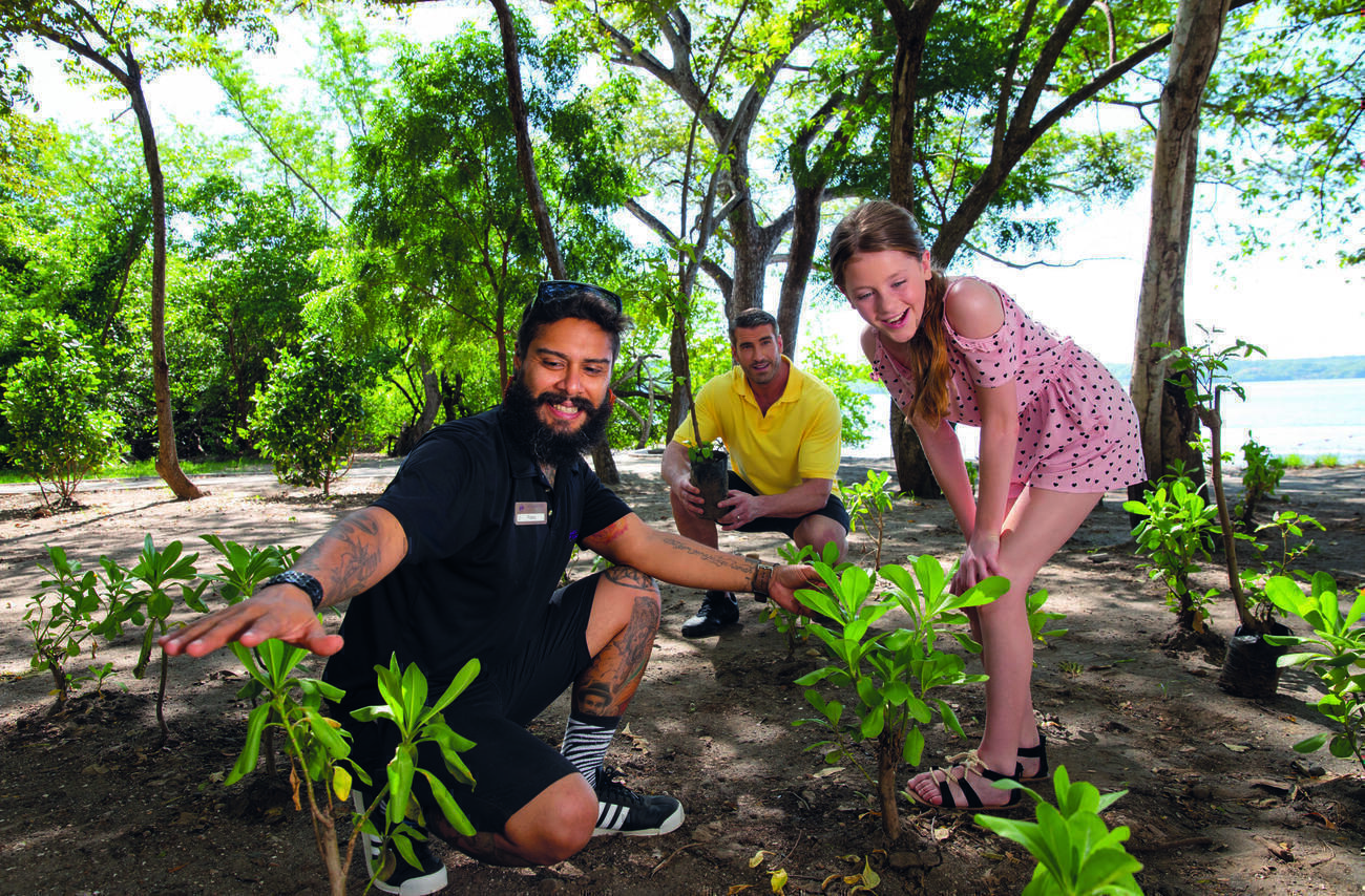 Two men and a girl looking at different plants