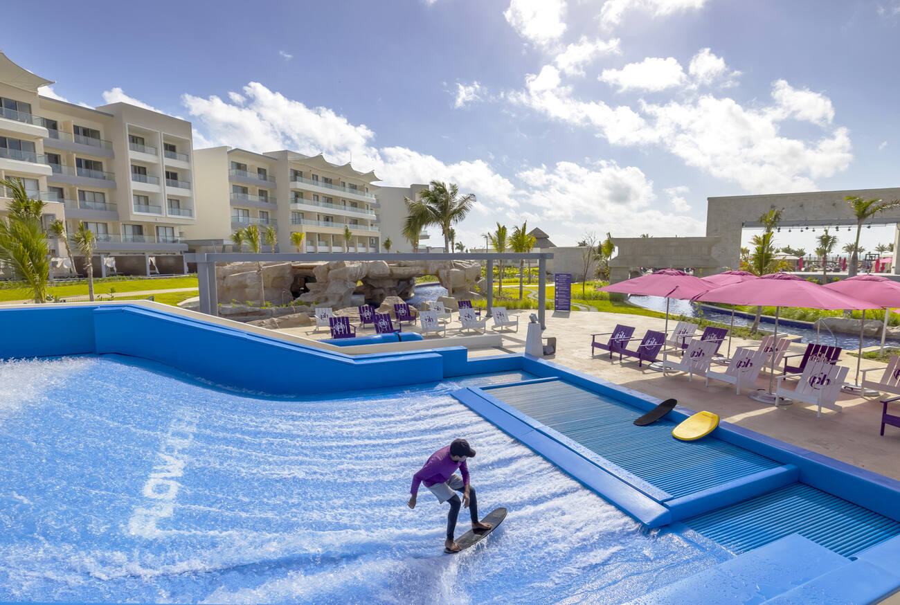 Man on a resort doing a surfing simulator 