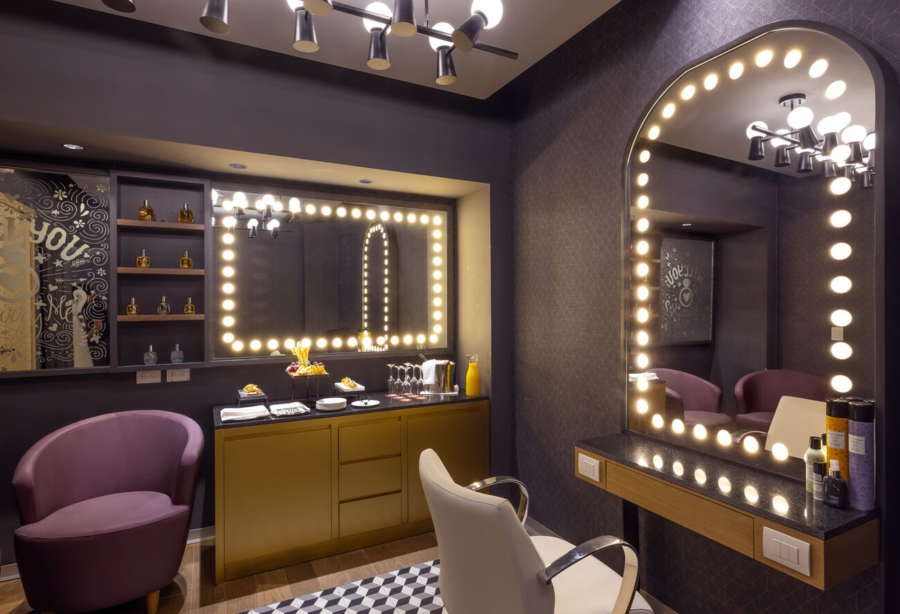 Spa room with lit up mirror with mimosas and fruit platters