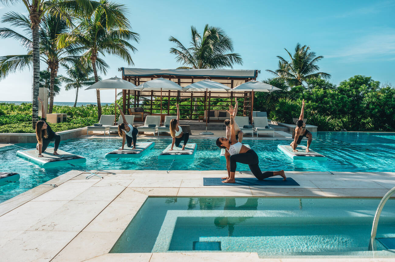 Group doing yoga on boards in the pool