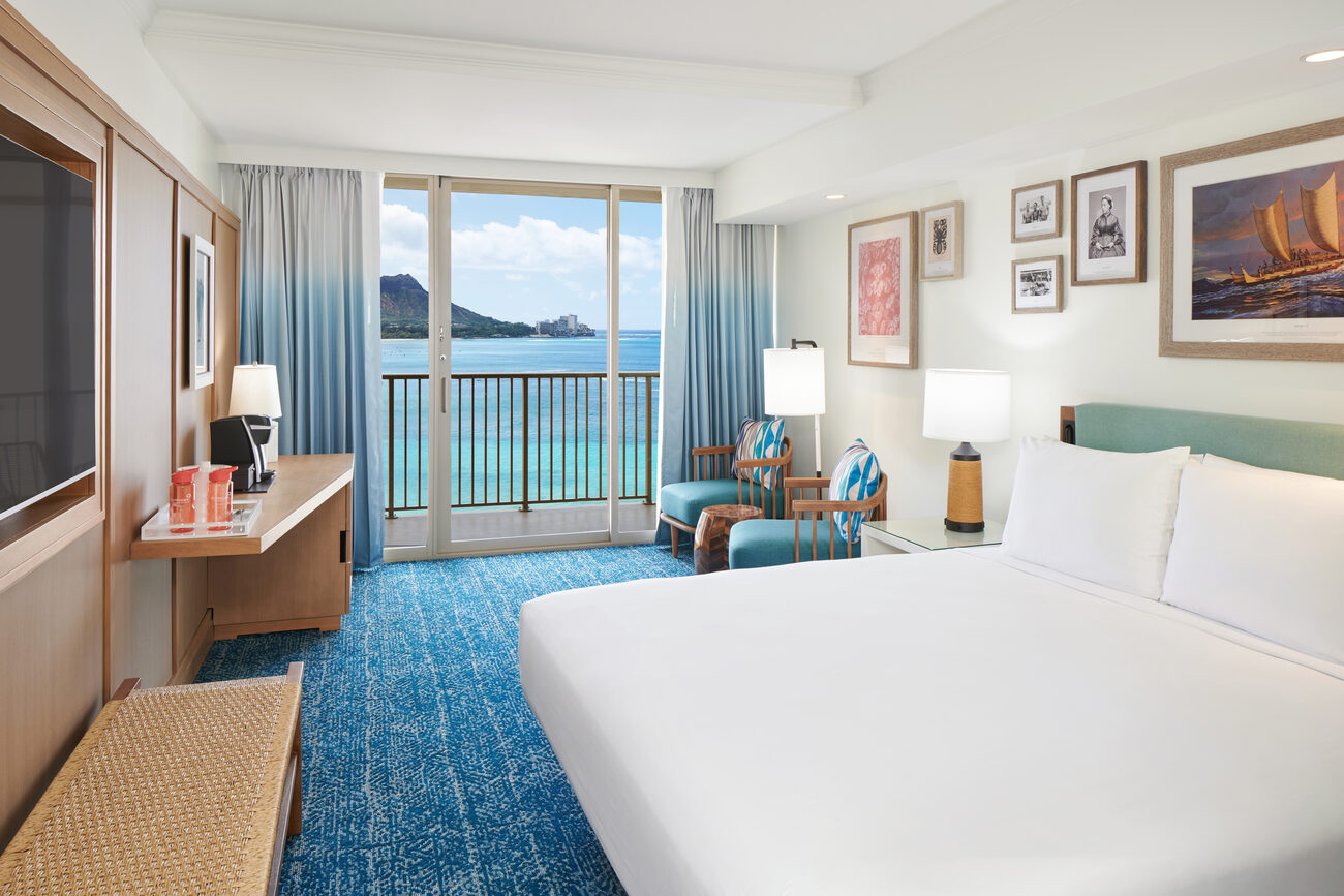 Hotel bed with seating on deck overlooking the ocean