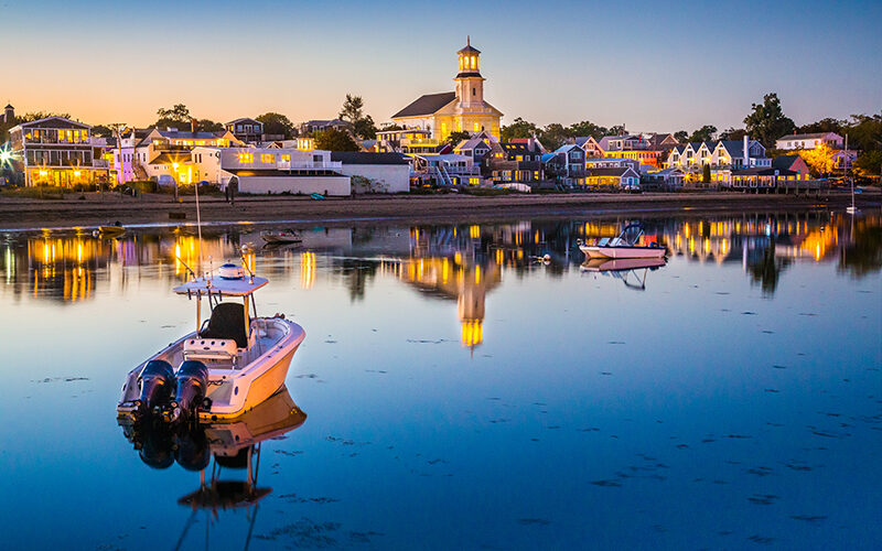 Boats on the water and waterfront homes at sunset in Provincetown