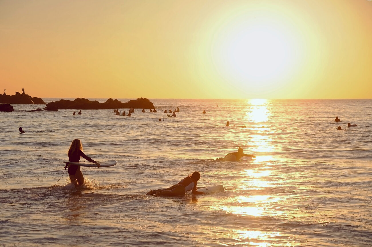 Surfers ride out at sunset