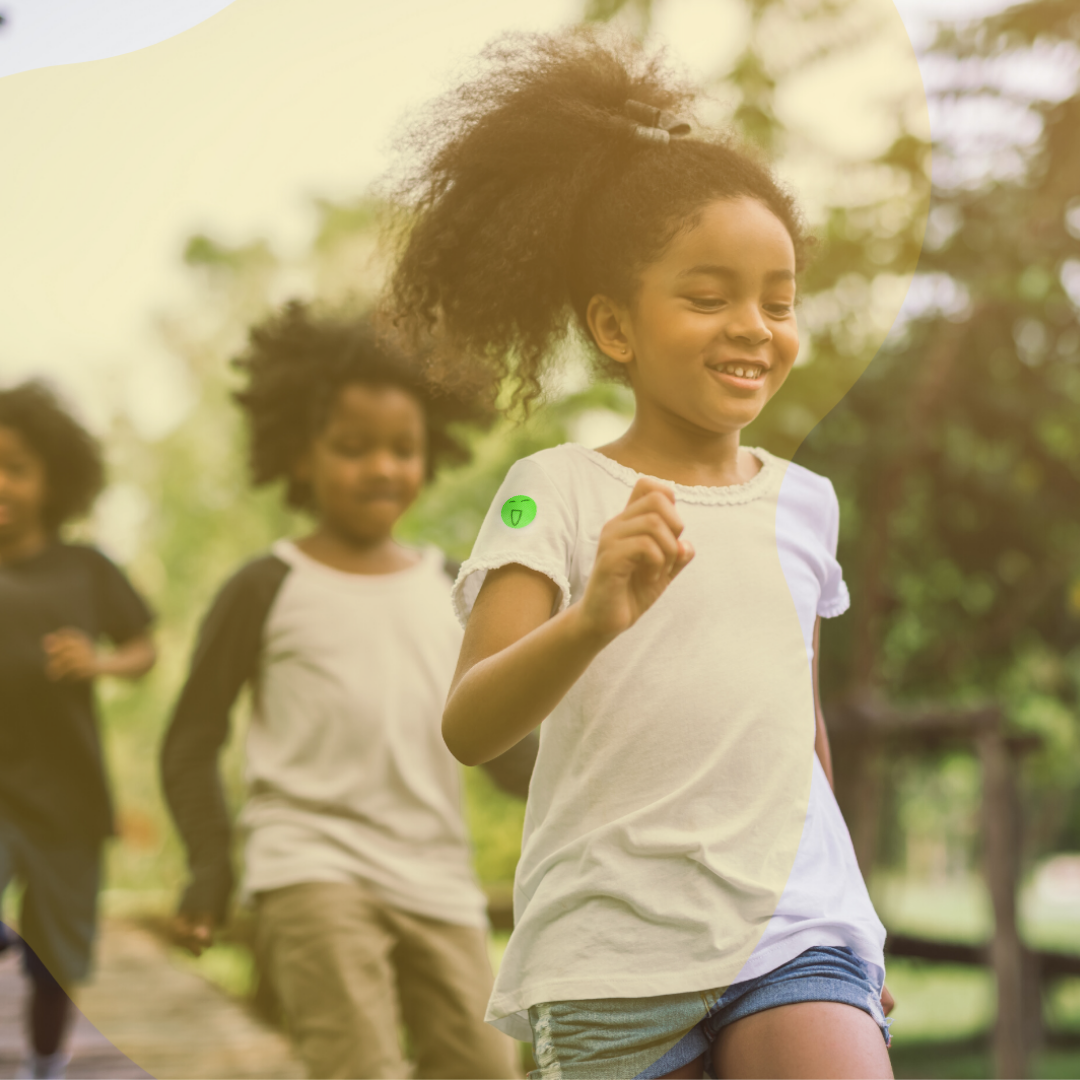 Kids running with a young girl wearing a mosquito patch on her arm