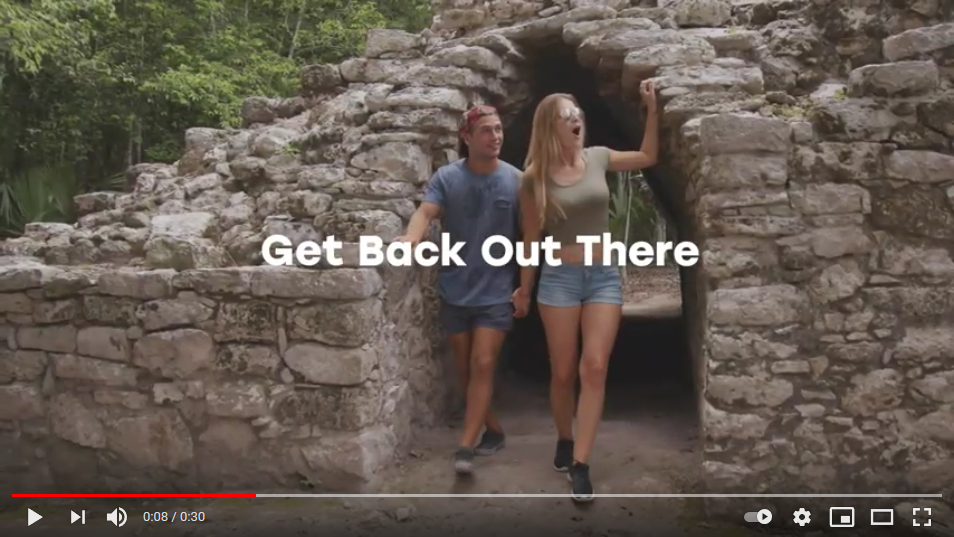 Couple holding hands and looking at ruins in Tulum