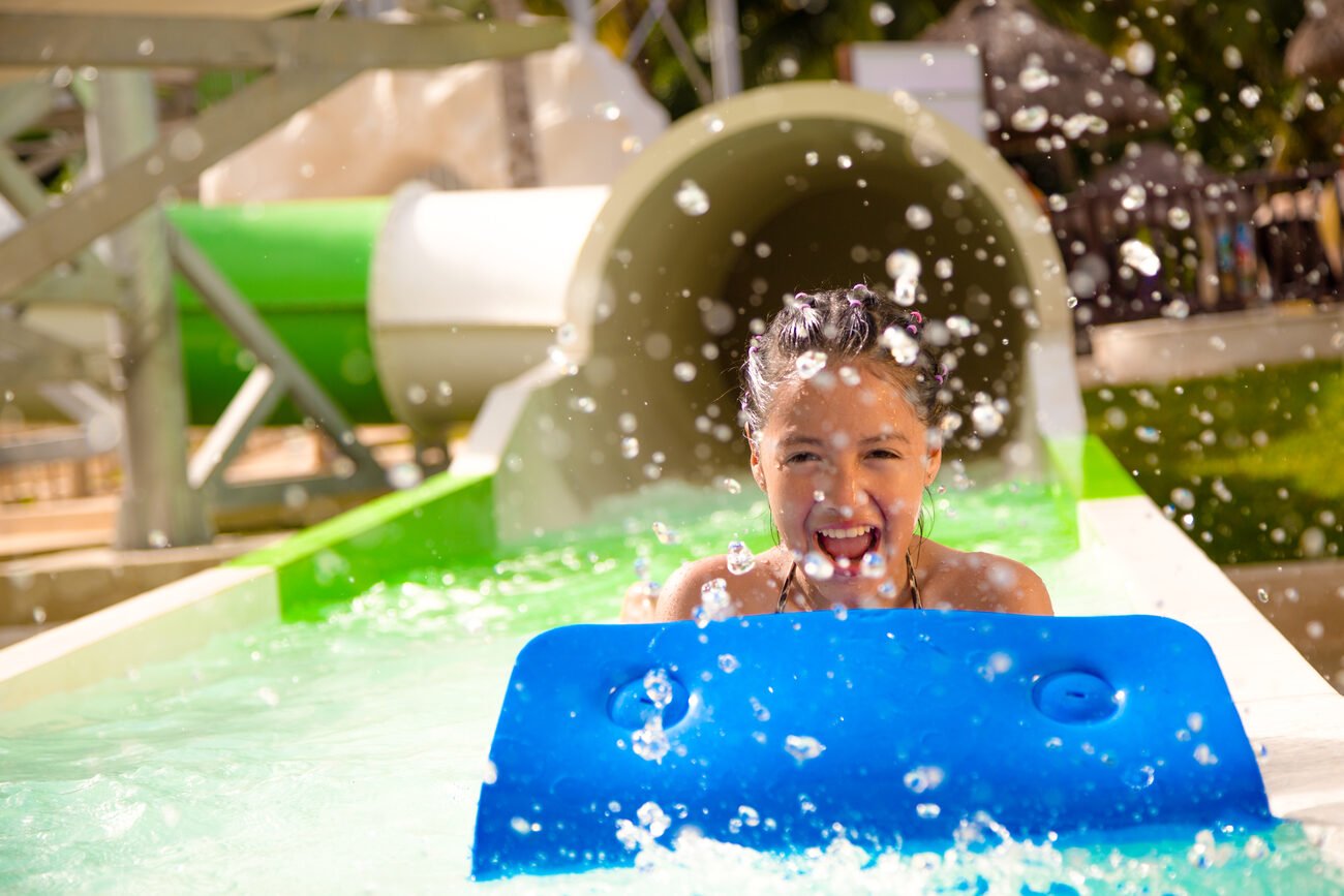 Girl coming down a waterslide splashing water