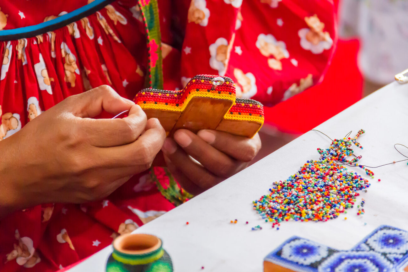 Woman creating traditional beaded craft