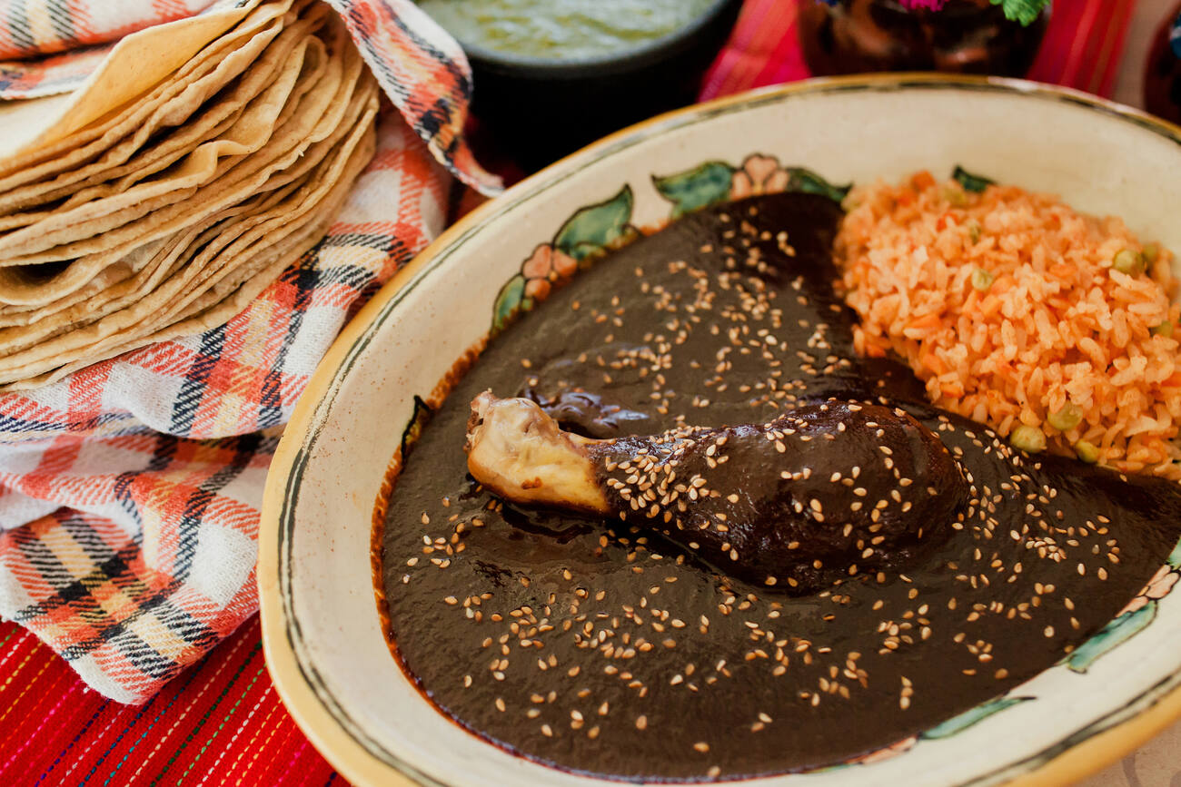 A chicken and rice dish topped with mole poblano