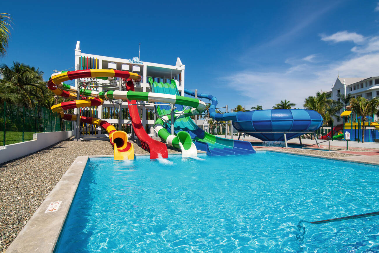 Four waterslides by each other going into a pool