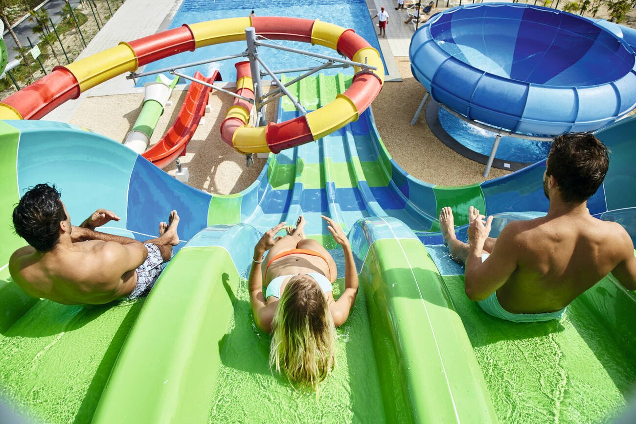 Two people going down a racing waterslide