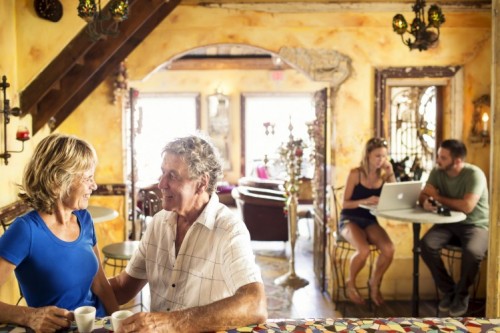 People sitting in a cafe drinking coffee and working on a laptop