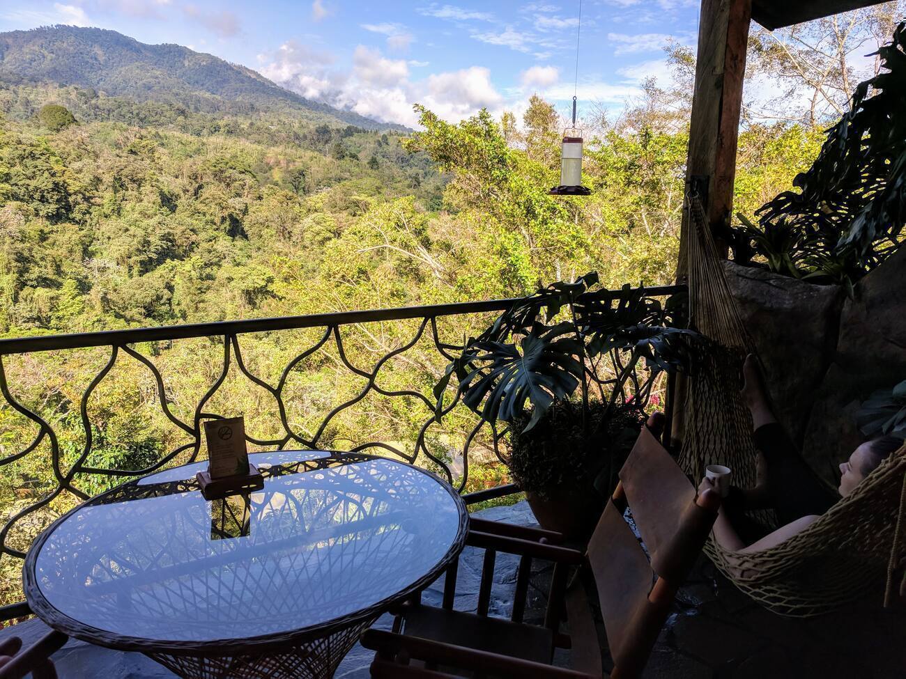 Woman drinking coffee in a hammock on a balcony