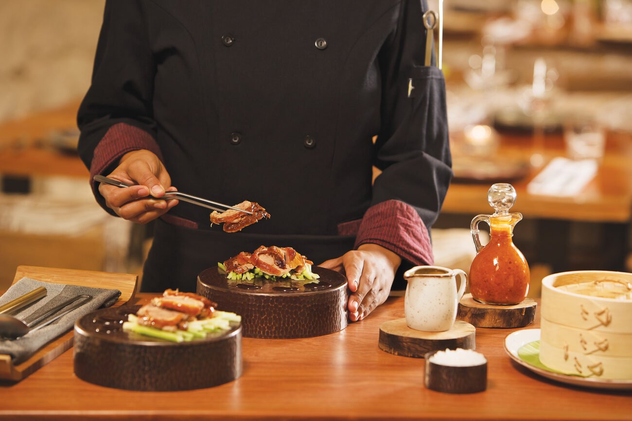 Meat being plated onto a dish