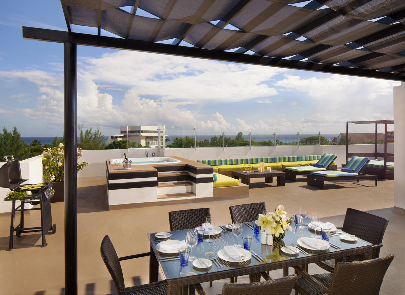 Balcony with dining table, hot tub, and lounge chairs