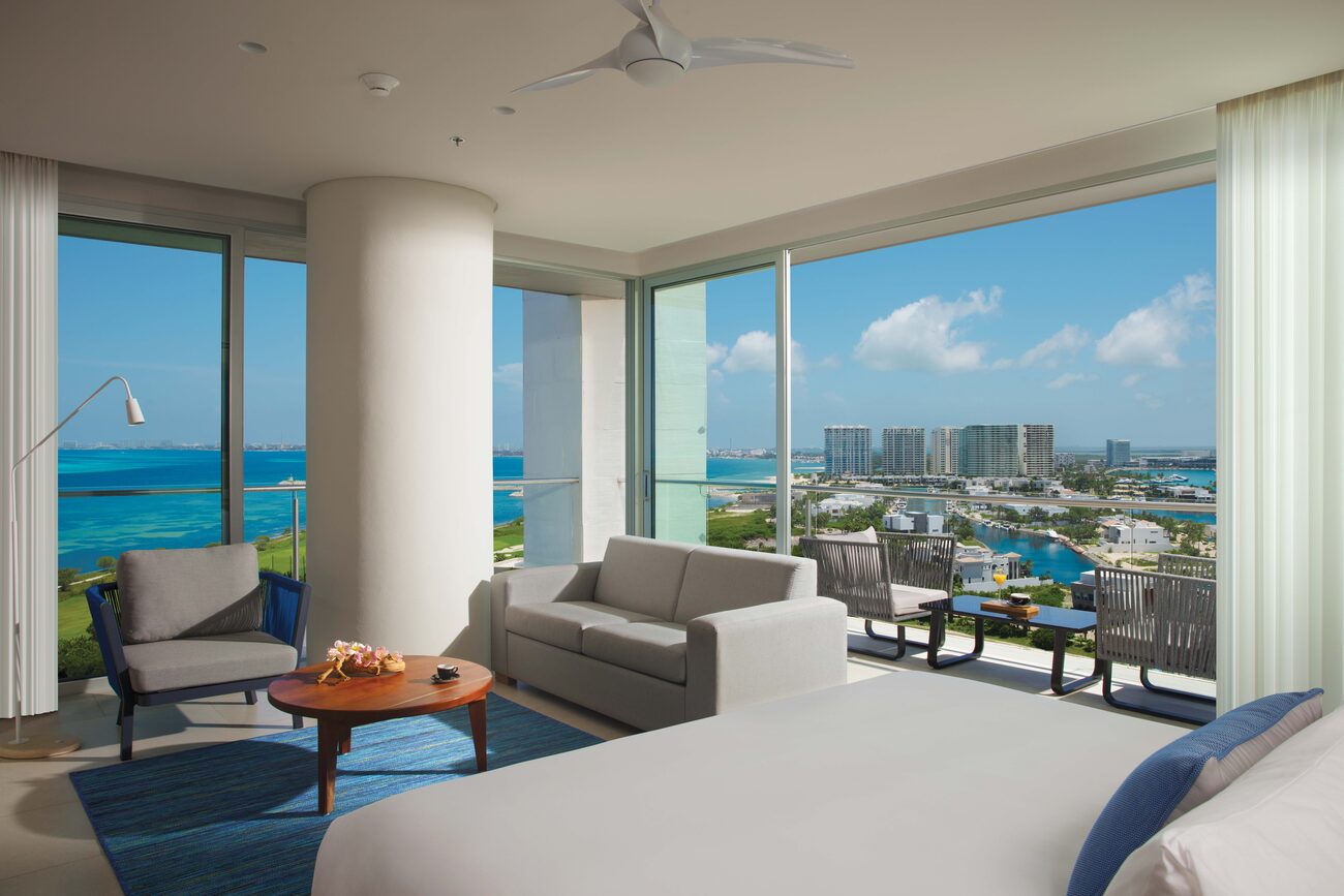 Hotel room with large glass windows looking out on the ocean