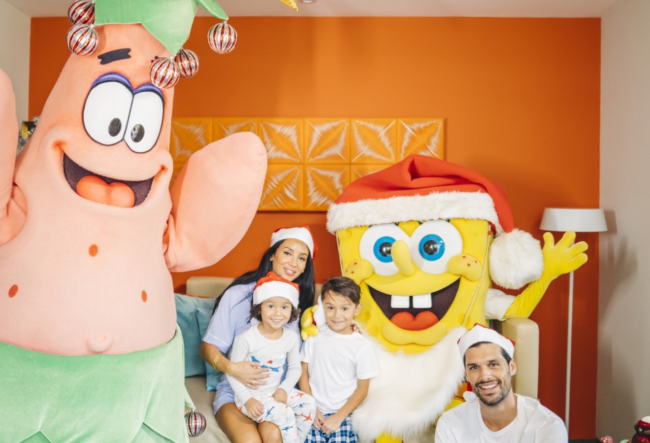 Spongebob and Patrick posing with a family in Santa hats