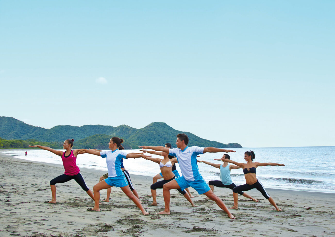 Group doing yoga on the beach