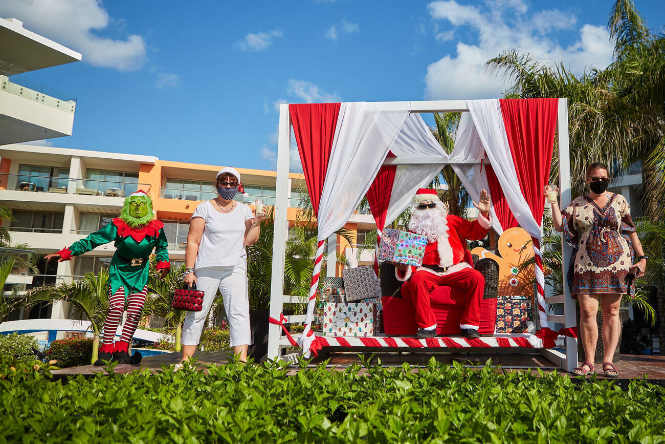 Santa and the grinch sitting with presents