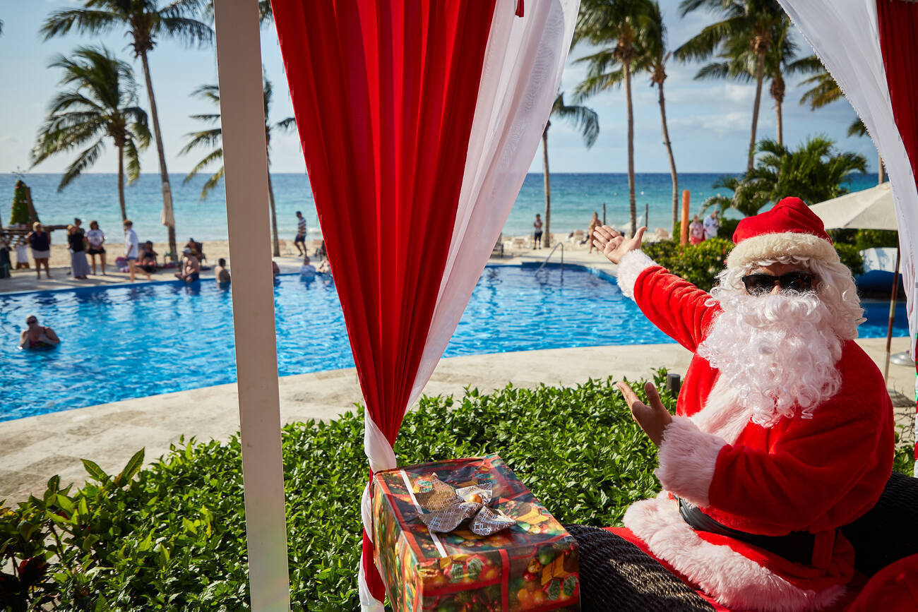 Santa with sunglasses pointing at the pools and ocean