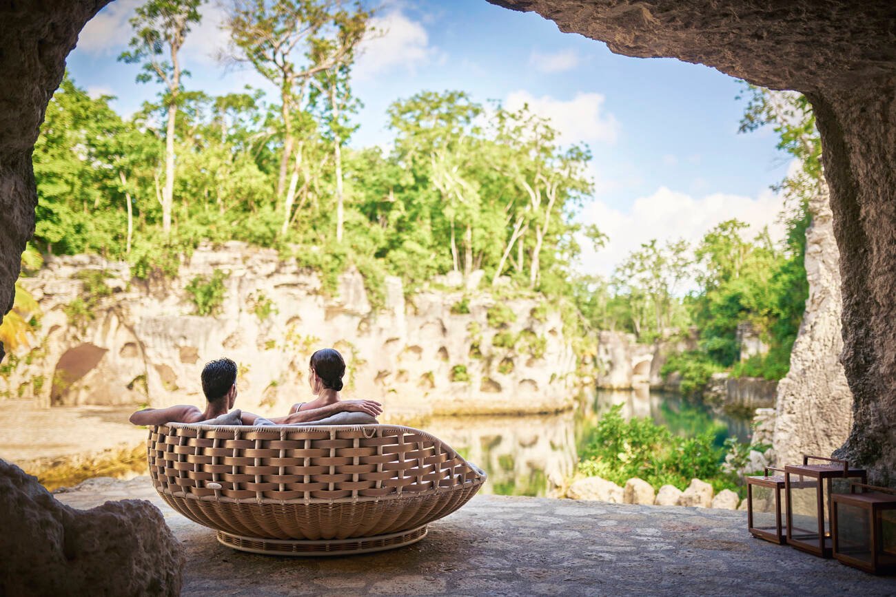 Couple sitting on a wooden chair overlooking the water