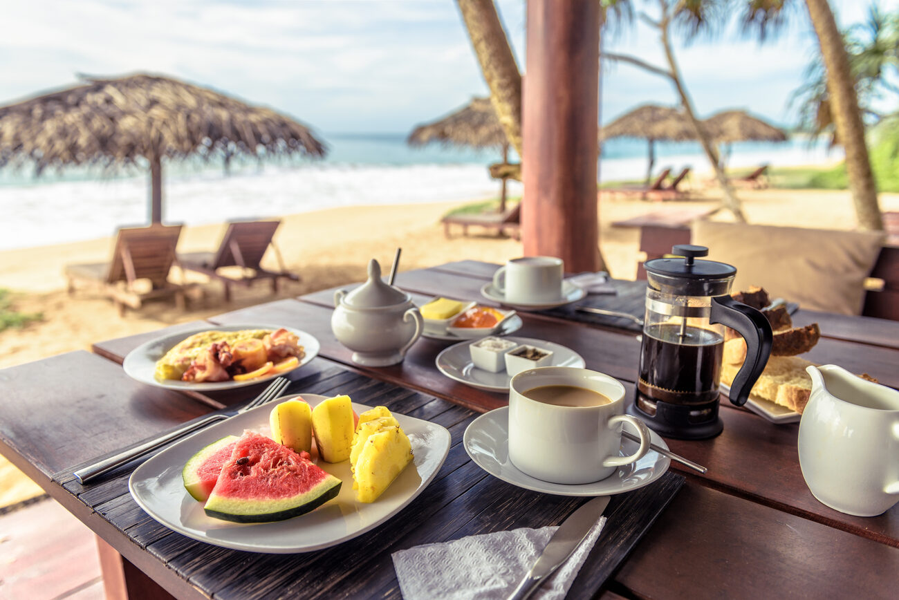 Table of breakfast food and coffee on the beach 